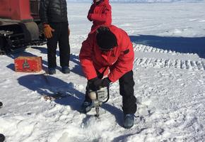 Hanna drilling into a sea ice crack to measure depth